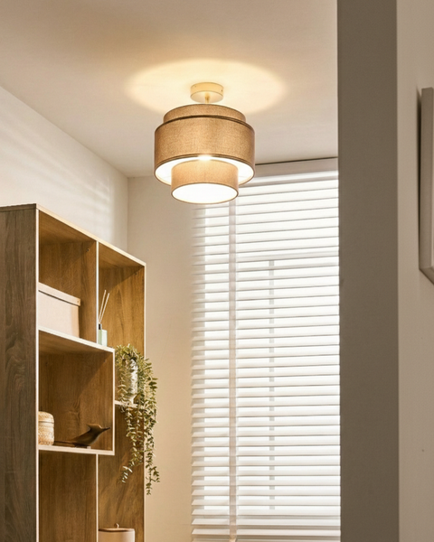 Moderne zweistufige Textil-Deckenleuchte in einem hellen Raum mit einem Holzregal und weißen Jalousien.