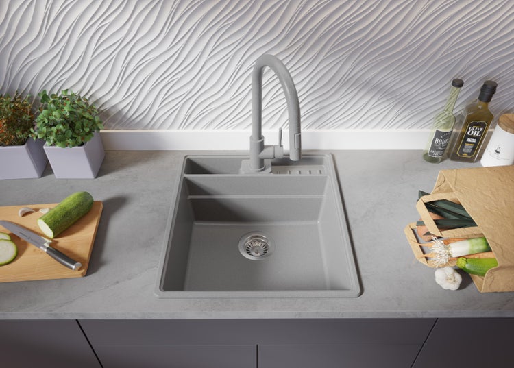 Graue Küchenspüle mit Abtropffläche und Armatur auf einer Küchentheke