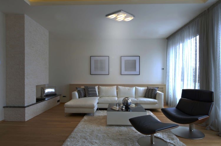 Helles Wohnzimmer mit Sofa, Sessel, Teppich und Kamin