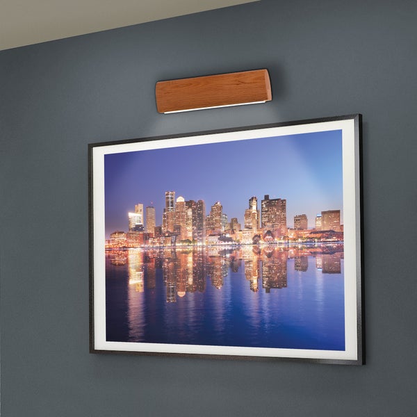 Wand mit gerahmtem Bild einer Stadt und Holzlampe