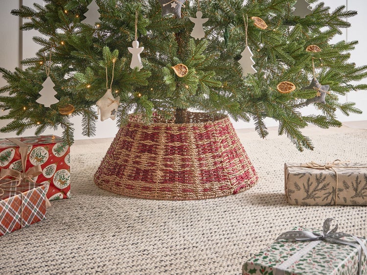 Weihnachtsszene mit Weihnachtsbaum, Baumschmuck, Geschenken und einer rot-braunen Baumdecke aus Seegras