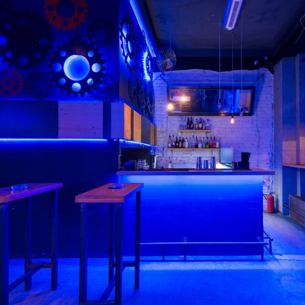 Innenansicht einer Bar mit Tischen, Barhockern und Dekoration mit Zahnrädern