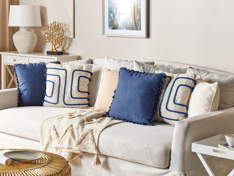 Wohnzimmer-Szene mit Sofa, Kissen und dekorativen Elementen für eine gemütliche Atmosphäre.