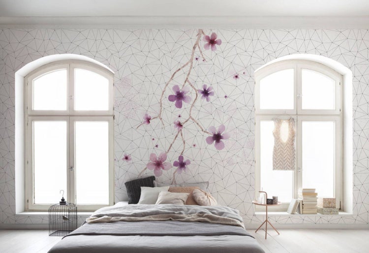 Schlafzimmer mit Bett, Fenster und geometrischer Blumentapete