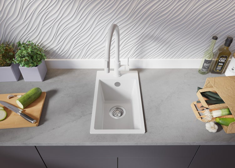 Küchenszene mit Spüle, Armatur, Schneidebrett mit Zucchini, Einkaufstüte mit Gemüse und Kräutertöpfen