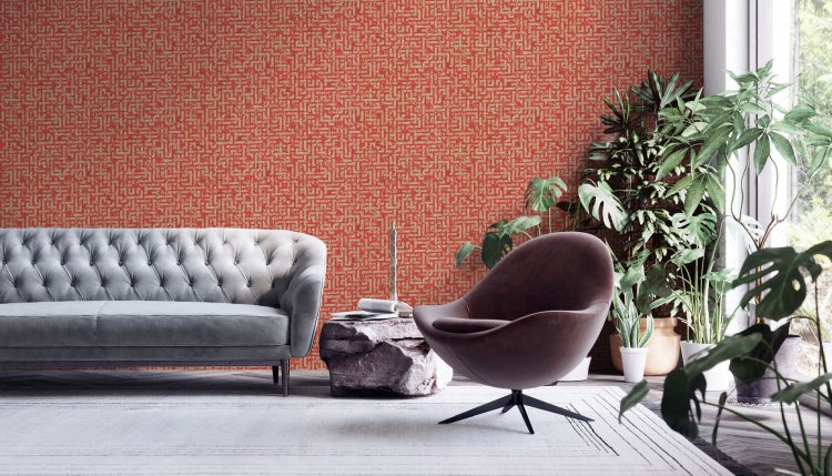 Wohnzimmer mit Sofa, Sessel und rot gemusterter Tapete