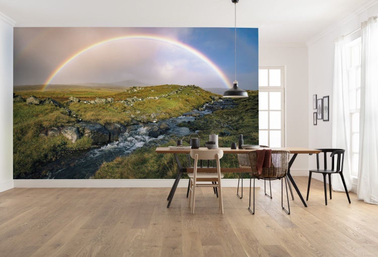 Wohnraum mit Fototapete einer Landschaft mit Regenbogen über einem Bach