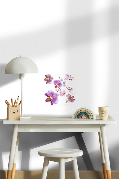 Kinderzimmer mit Schreibtisch, Lampe, Stuhl, Farbstiften, Spielzeugregenbogen, Tasse und Wandtattoo Orchidee