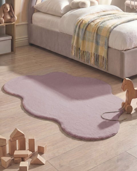 Weicher Teppich in Wolkenform für das Kinderzimmer auf einem hellen Holzboden neben einem gepolsterten Bett und Holzspielzeug.