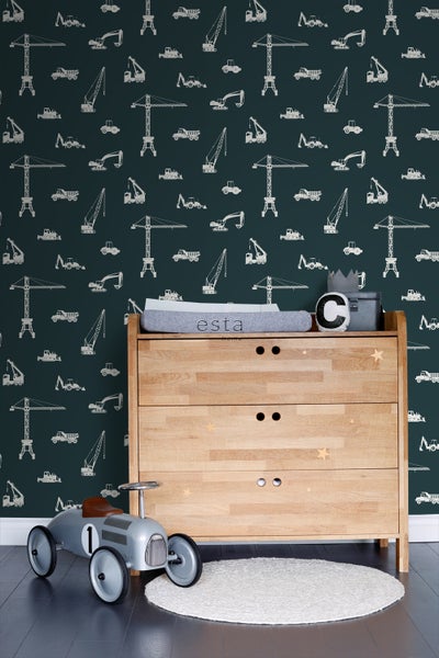 Kinderzimmer mit Baufahrzeugtapete, Holzkommode, Spielzeugauto und rundem Teppich