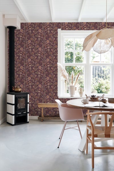 Wohnzimmer mit floraler Tapete, Sessel und weißem Schrank