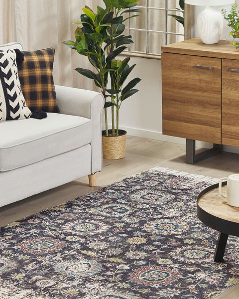 Dekoratives Interieur mit Rattanbank, Kissen und gemustertem Teppich