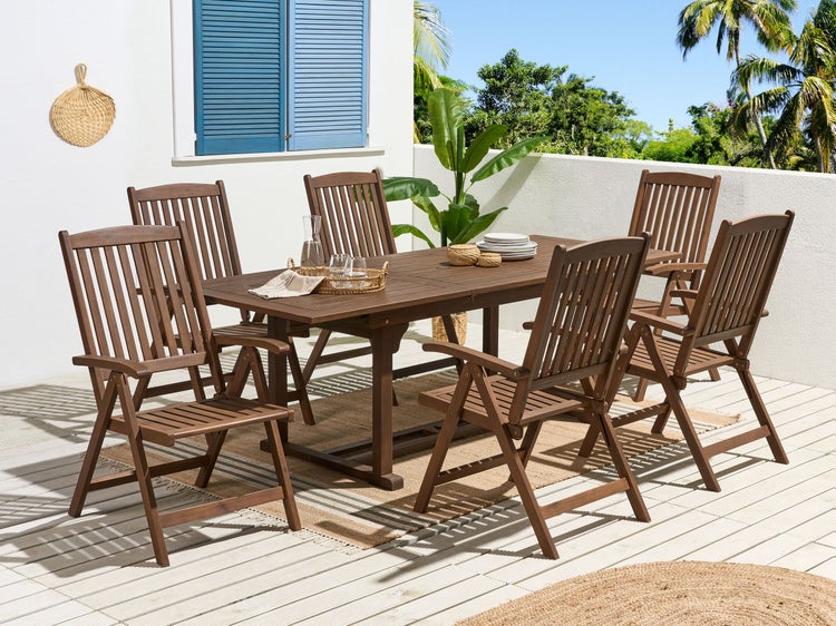 Gartenszene mit einem Holzesstisch und sechs Holzstühlen auf einer Terrasse