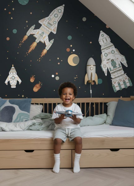 Kinderzimmer mit Weltraum-Tapete, Raketen-Wandtattoos, einer Raketen-Wandleuchte und einem hölzernen Funktionsbett.