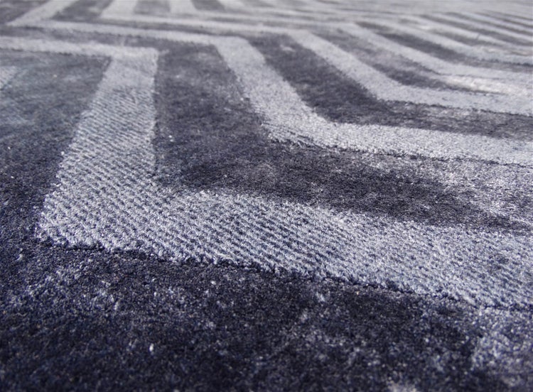 Nahaufnahme eines Teppichs mit Zickzack-Muster und gewebter Oberfläche.