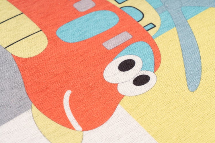 Detailaufnahme eines Kinderteppichs mit buntem Flugzeugmotiv und gewebter Oberflächenstruktur.