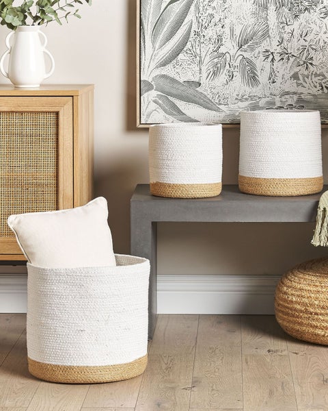 Set aus drei zweifarbigen Seilkörben in Weiß und Natur, in einem hellen Zimmer mit Bank, Rattanschrank und Bodenkissen.