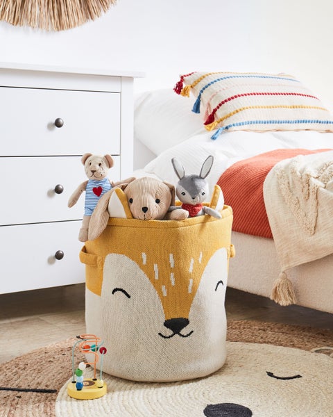 Kinderzimmer mit Kommode, Bett, Spielzeug und Aufbewahrungskorb mit Tiermotiv