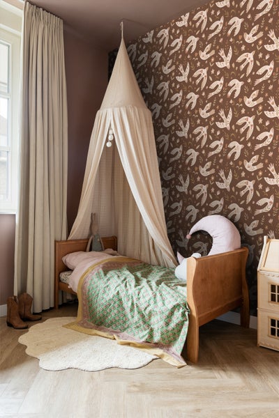 Kinderzimmer mit Himmelbett, Holzbett, gemusterter Tapete und Teppich