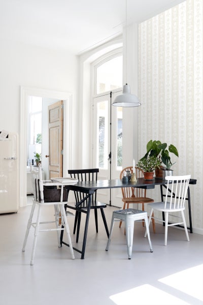 Heller Raum mit Esstisch, Stühlen und Tapete mit Muster