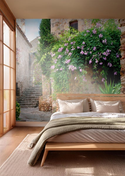 Fototapete mit Motiv einer Gasse mit Treppe und blühenden Pflanzen im mediterranen Stil