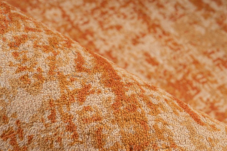 Nahaufnahme der weichen Oberflächenstruktur eines gemusterten Teppichs.