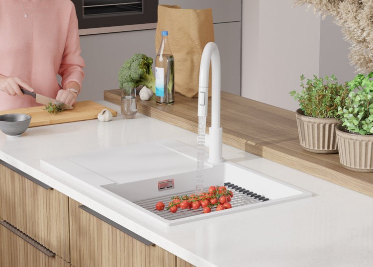 Küchenszene mit Spüle, Armatur, Gemüse und Küchenutensilien auf einer Arbeitsplatte