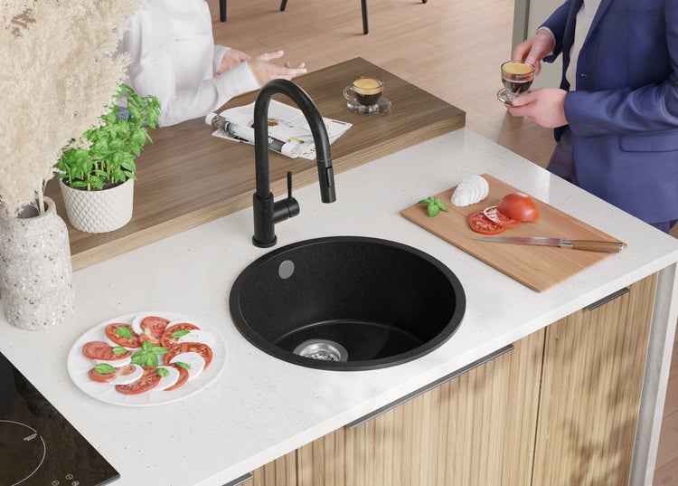 Küchenszene mit Spüle, Armatur, Kochfeld und Speisen auf der Arbeitsfläche.