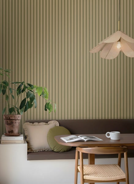 Essbereich mit gestreifter Tapete, Holztisch, Sitzbank und Zimmerpflanze