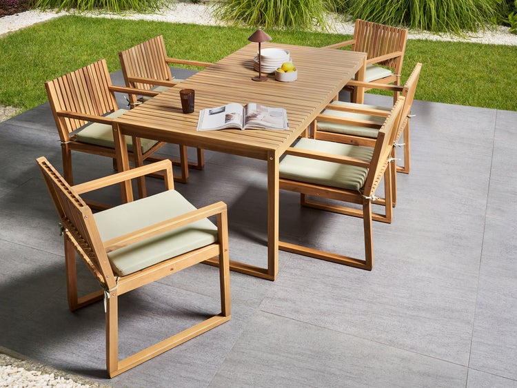 Gartentisch mit Stühlen aus Holz mit Auflagen auf einer Terrasse