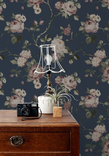 Blumentapete mit Rosenmuster im Vintage-Stil als Hintergrund für eine Lampe und eine Kommode