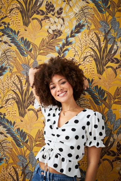 Innenraum mit gemusterter Dschungeltapete, Regal und Holzboden