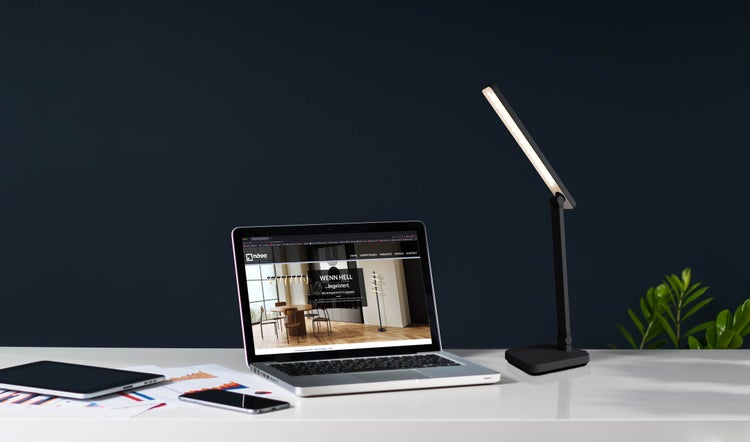 Schreibtisch mit Laptop, Tablet, Smartphone und LED-Tischleuchte