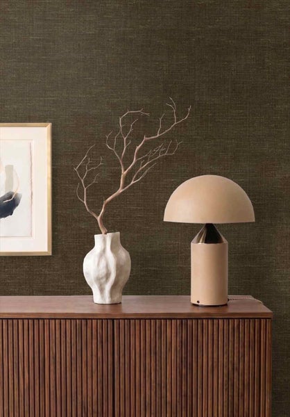 Dunkelbraune strukturierte Tapete in Leinenoptik hinter einem Holzsideboard mit moderner Tischleuchte und weißer Vase.