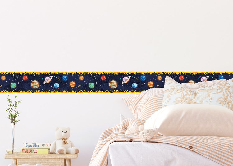 Tapetenbordüre mit Weltraum-Motiv, Planeten und Sternen an einer Wand über einem Tisch und Stühlen.