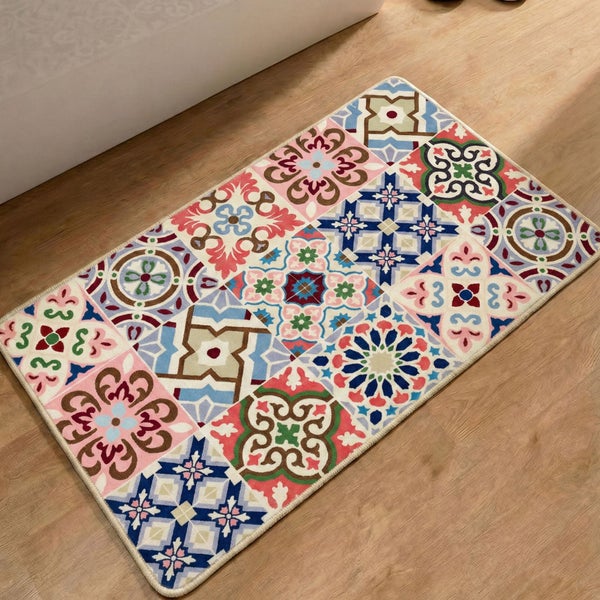 Rechteckiger Teppich mit buntem Mosaikfliesen-Muster und floralen Ornamenten auf Holzboden.