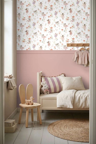 Ein Kinderzimmer mit Feen Tapete, rosa Wandtäfelung, Holzbett, Holzstuhl in Hasenform und Jute Teppich.
