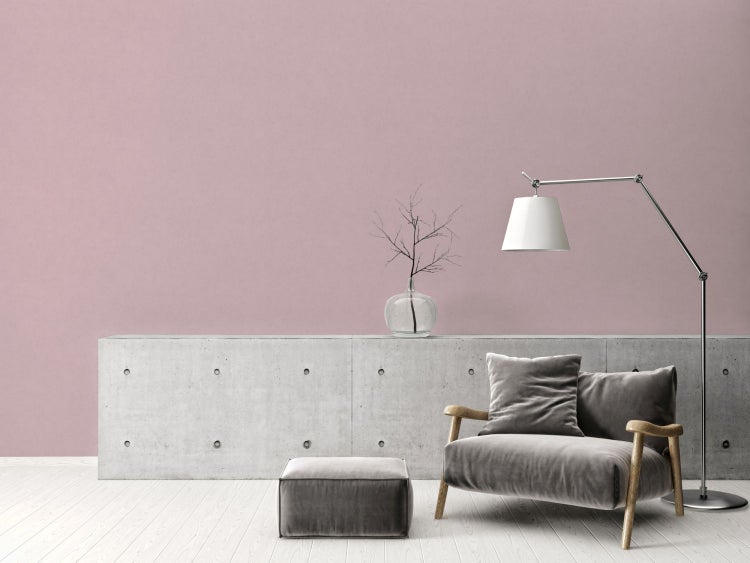 Wohnzimmer mit Sessel, Lampe und Betonsockel