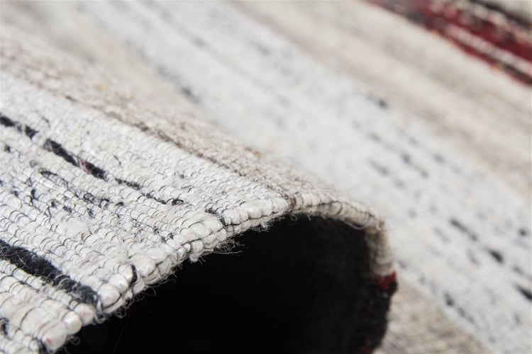 Nahaufnahme eines gewebten Teppichs mit sichtbarer Textur und flachgewebter Struktur.