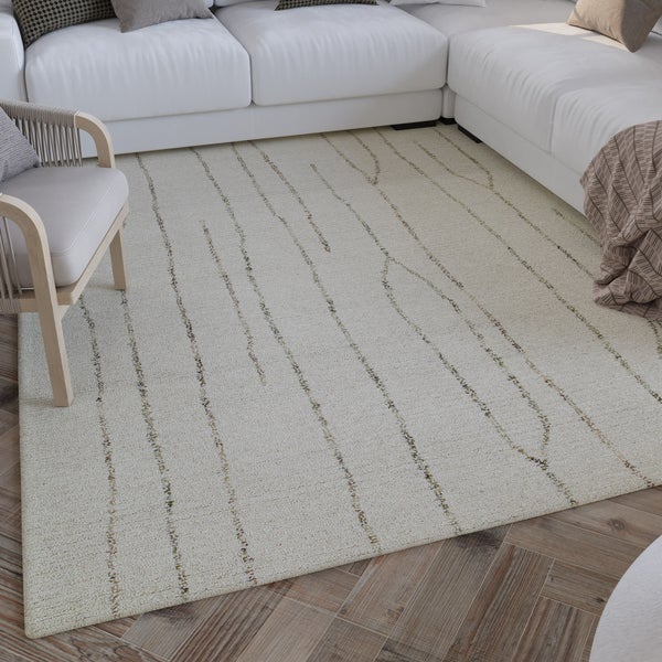 Moderner Teppich mit organischem Linienmuster in einem hellen Wohnzimmer mit weißem Sofa, Sessel und Parkettboden.