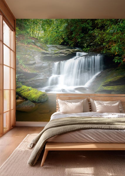Schlafzimmer mit Fototapete eines Wasserfalls im Wald