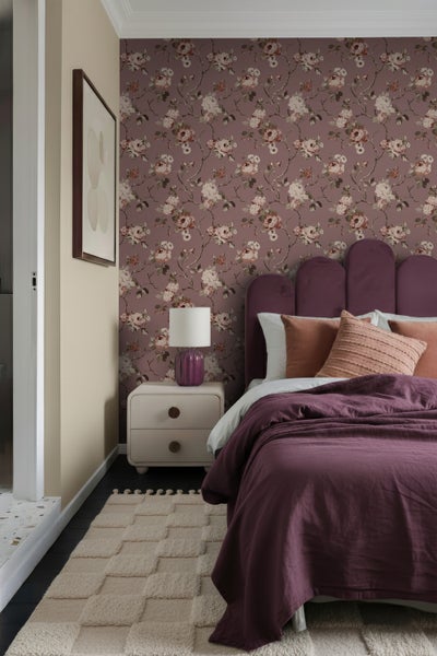 Dekoratives Schlafzimmer mit Blumtapete, Bett, Nachttisch und Teppich