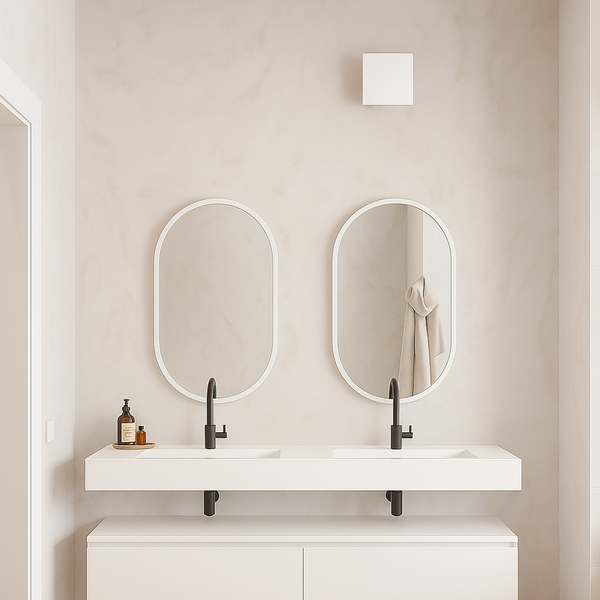 Badezimmer mit Doppelwaschtisch, ovalen Spiegeln und hellen Farbtönen für eine freundliche Atmosphäre