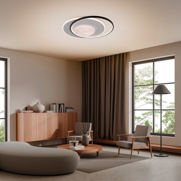 Helles Wohnzimmer mit moderner Deckenleuchte, Sofa und Sesseln