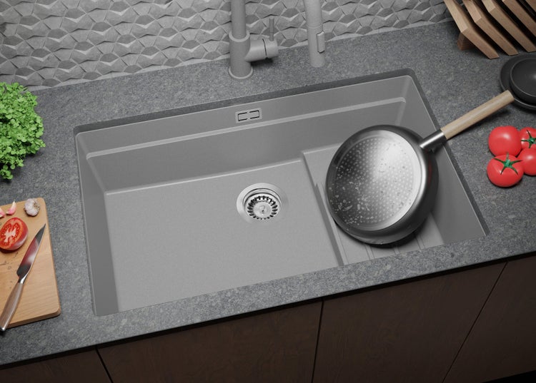 Spüle mit Armatur, Spülbecken, Schneidebrett und Kochutensilien auf einer Arbeitsplatte