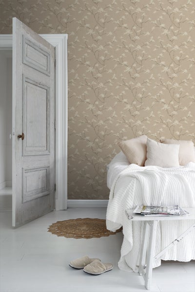 Wohnzimmer mit gemusterter Tapete, Sofa, Teppich und Pflanze