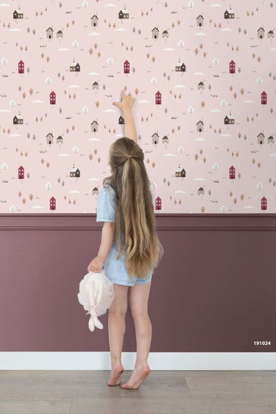 Kindertapete mit Häusermuster und Bäumen über einer dunklen Wandpaneele in einem hellen Kinderzimmer.