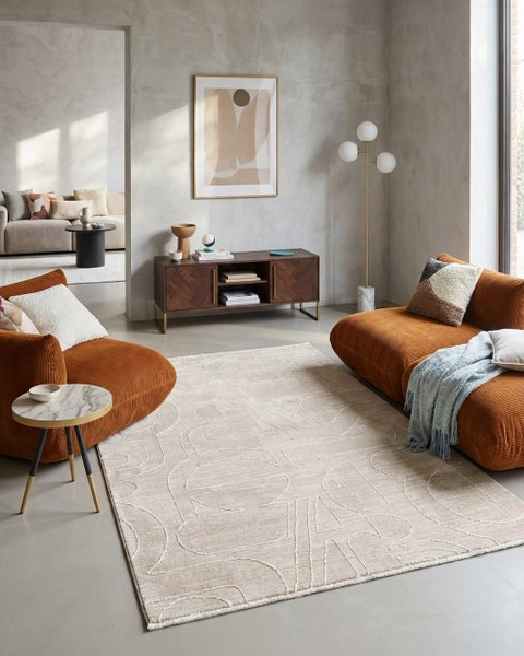Modernes Wohnzimmer mit großem gemustertem Teppich, rostbraunen Cord-Sofas, einem dunklen Holz-Sideboard und stilvoller Beleuchtung.