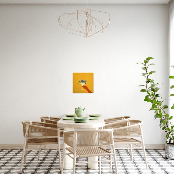 Esszimmer mit Esstisch, Stühlen, Zimmerpflanze, Pendelleuchte und gerahmtem Bild an der Wand.