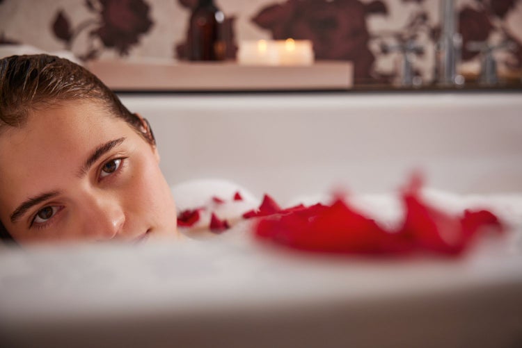 Wohnzimmer mit grauer Couch, Sessel und Tapete mit Rosenmuster